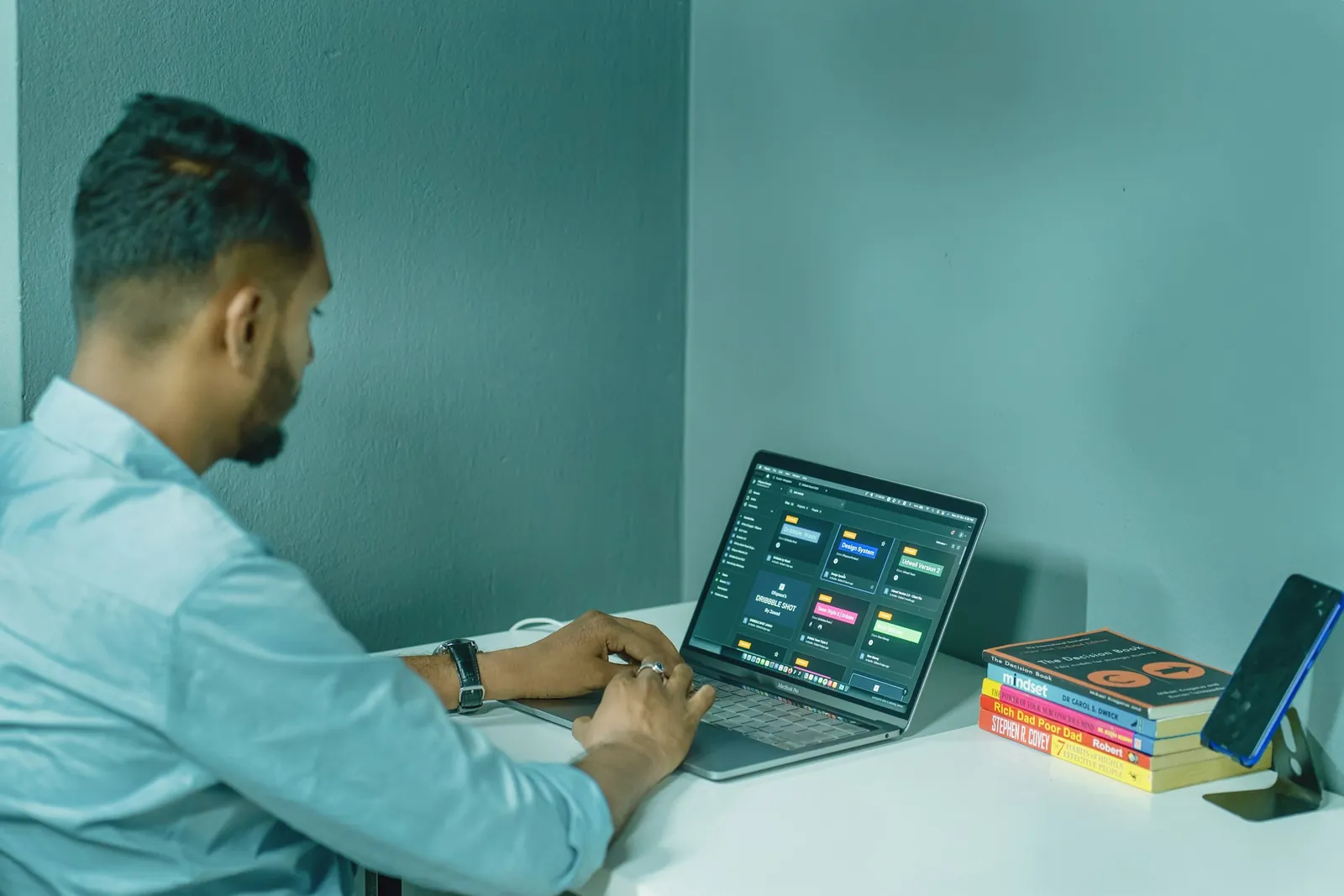 A person working at a desk with a laptop and notes